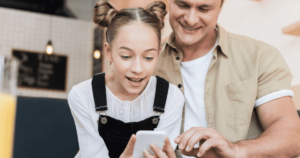 A dad uses a smartphone with his child.