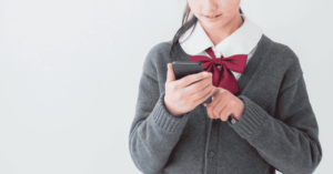 Girl on a school uniform playing with her smartphone