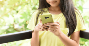 A young girls holds a smartphone.