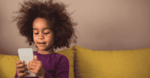 A little girl uses a smartphone.