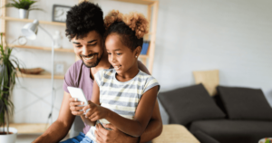 A man and his daughter using a smartphone