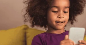 A little girl uses a smartphone.