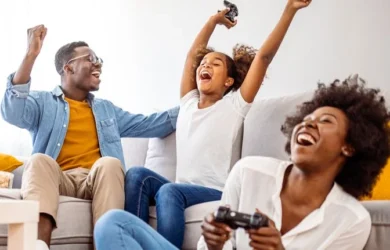 A family plays video games together with the child cheering their success.