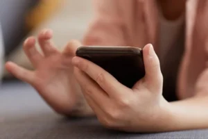 A child holds and uses their smartphone.