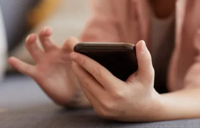 A child holds and uses their smartphone.