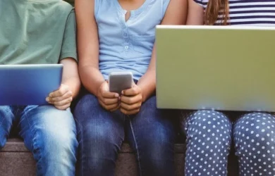 Three children use different connected devices.